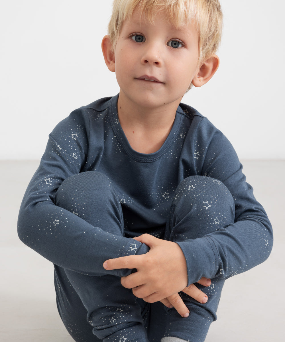 Dreng iført mørkeblåt pyjamasæt med stjerneprint