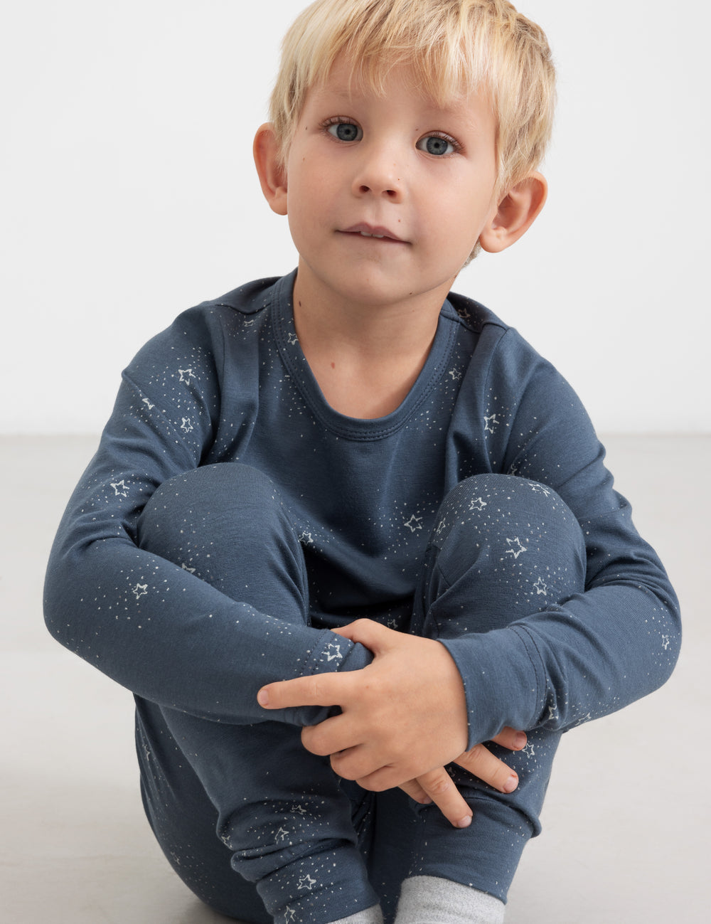 Dreng iført mørkeblåt pyjamasæt med stjerneprint