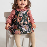 Baby iført støvet rosa body og blomsterprintet kjole