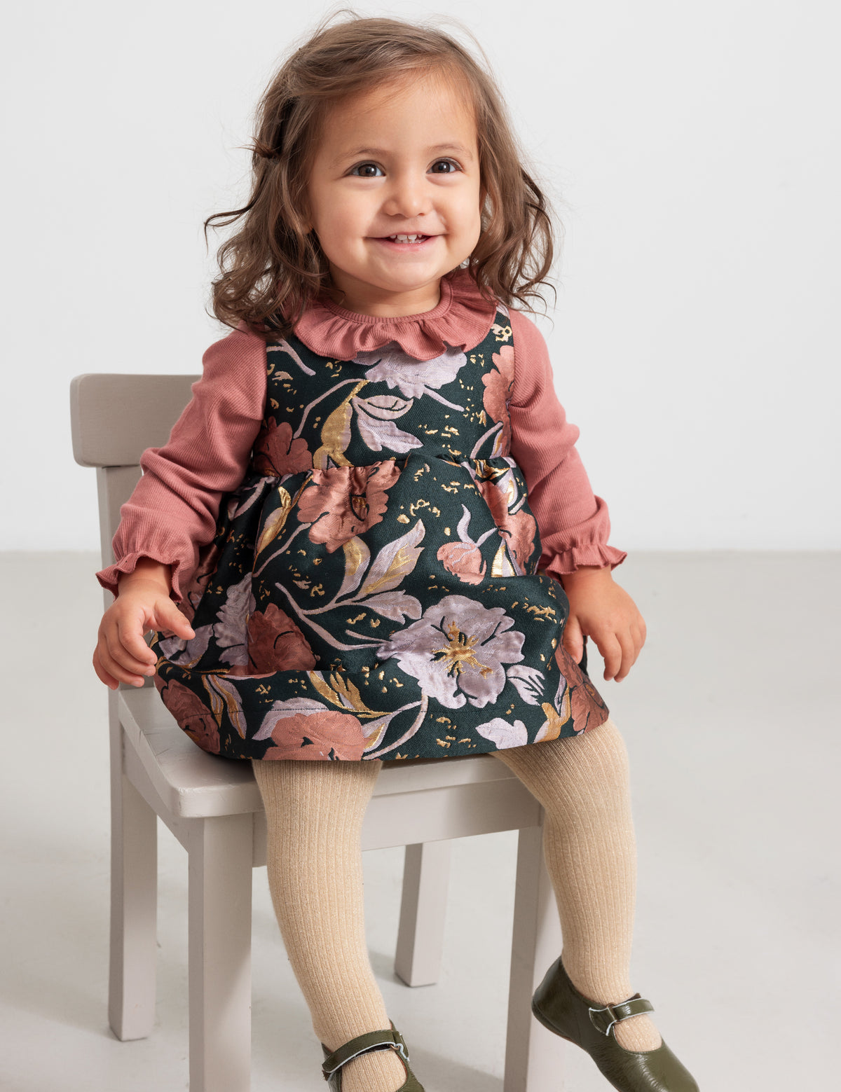 Baby i blomstret kjole med rosa bluse og strømpebukser