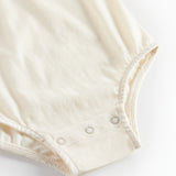 Hvid bodystocking med krave og fine blomsterbroderier til baby