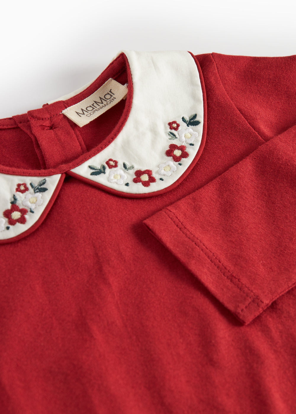 Julerød baby bodystocking med hvid krave og fine blomsterbroderier