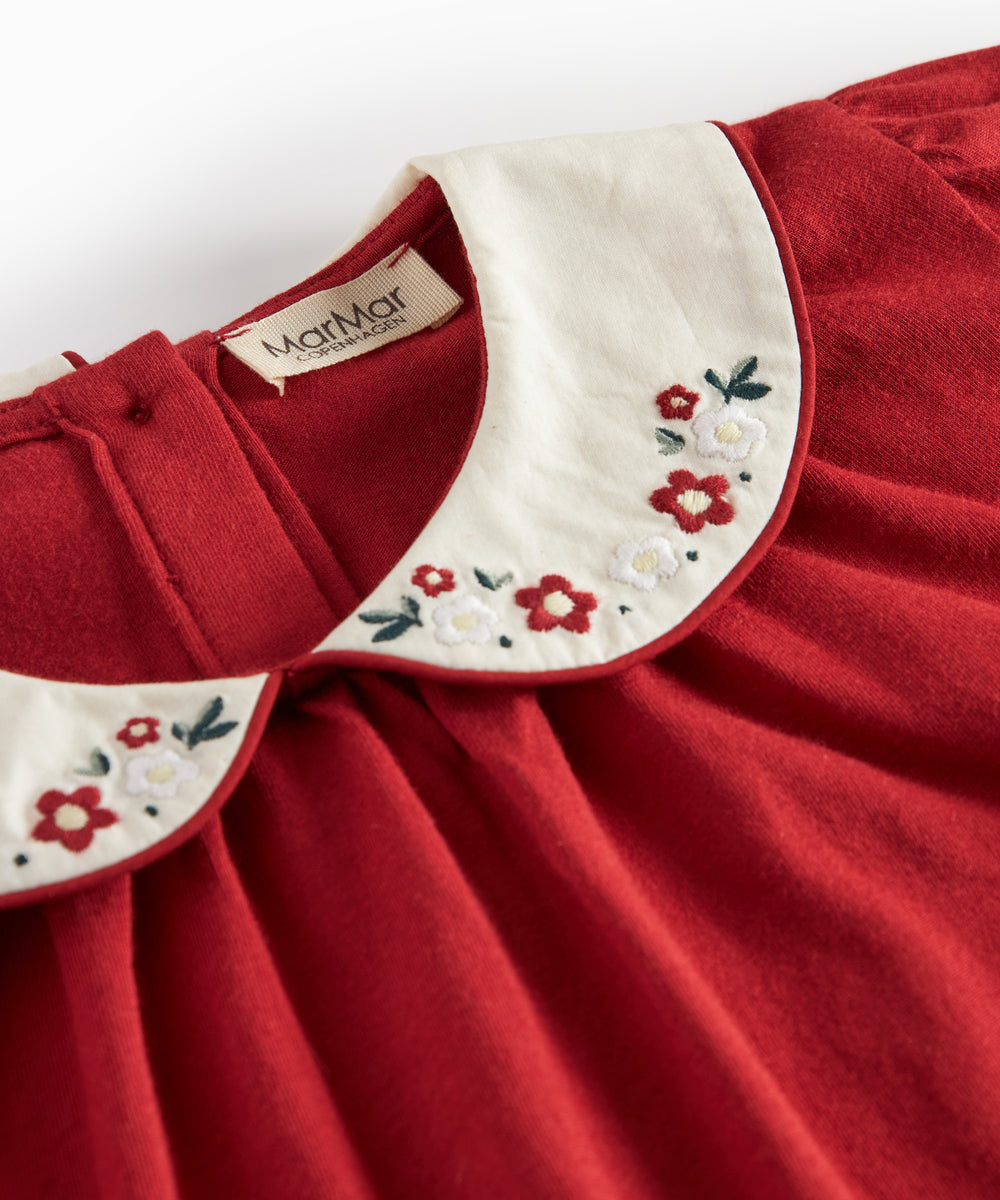 Rød julebluse med hvid krave og små blomsterbroderier til børn