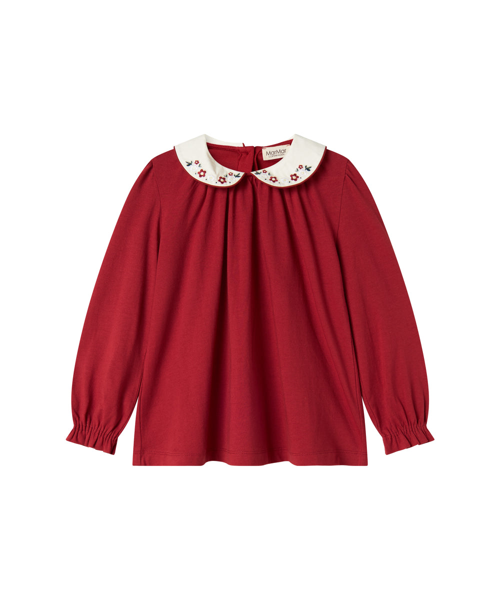 Rød julebluse med hvid krave og små blomsterbroderier til børn