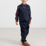 Dreng iført mørkeblå bukser og ternet skjorte i julelook til børn