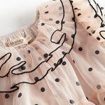 Nærbillede af krave med sorte flæser og prikker på lys beige julekjole i tyl til børn