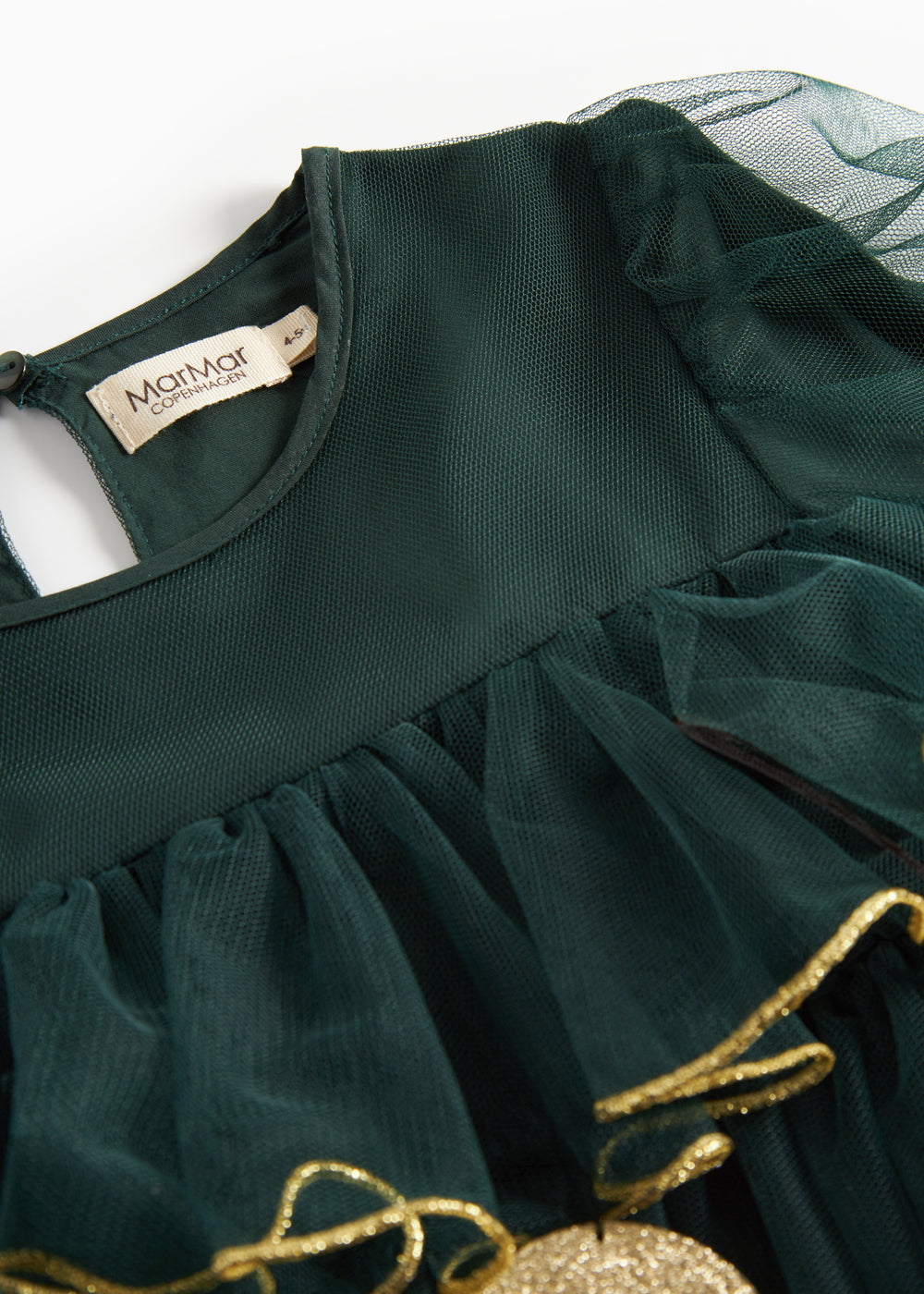 Nærbillede af mørkegrøn julekjole for børn i tyl med guldkanter og flæser