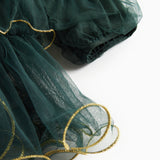 Nærbillede af mørkegrøn julekjole for børn i tyl med guldkanter og flæser