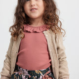 Pige iført støvet rosa bluse med flæsekrave og blomstermønstret nederdel