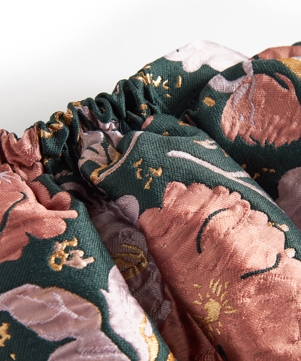 Kort mørkegrøn nederdel med store blomster og sløjfedetalje til børn