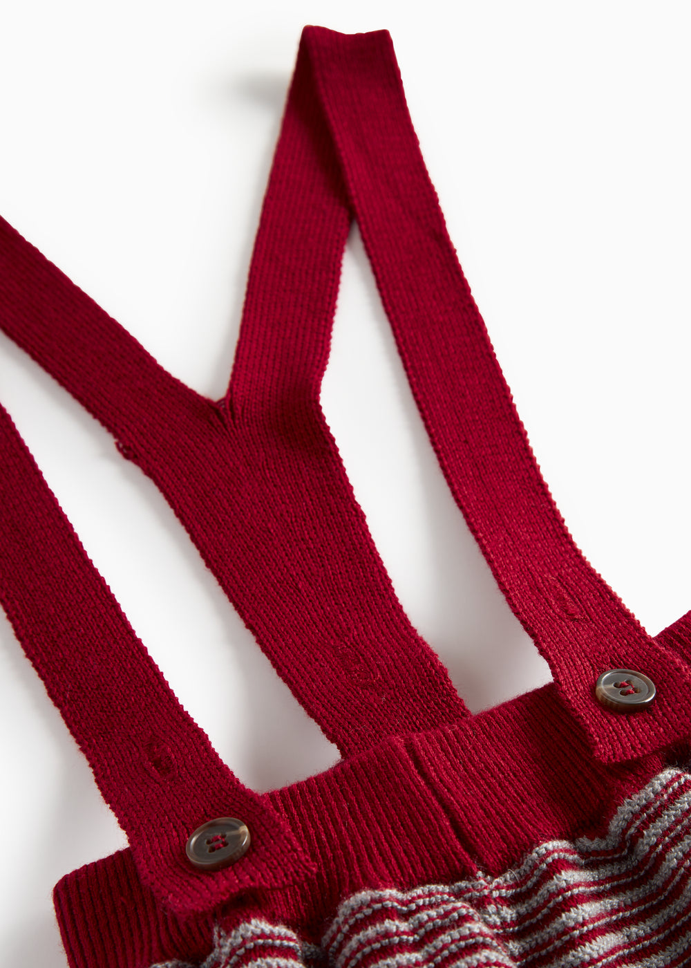 Strikkede bukser med røde og grå striber og seler til baby