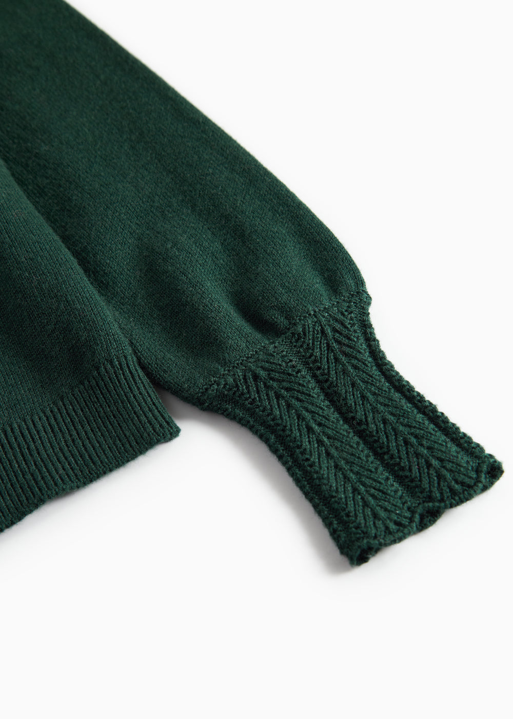 Ärme på mørkegrøn strikket cardigan med hulmønster og ribkanter til baby