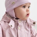 Wearing a yellow and striped raincoat with a hat and matching hat.