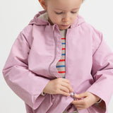 Child wearing a striped sweater with a bright red jacket.