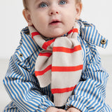 Baby wearing a blue striped raincoat and striped neckerchief.