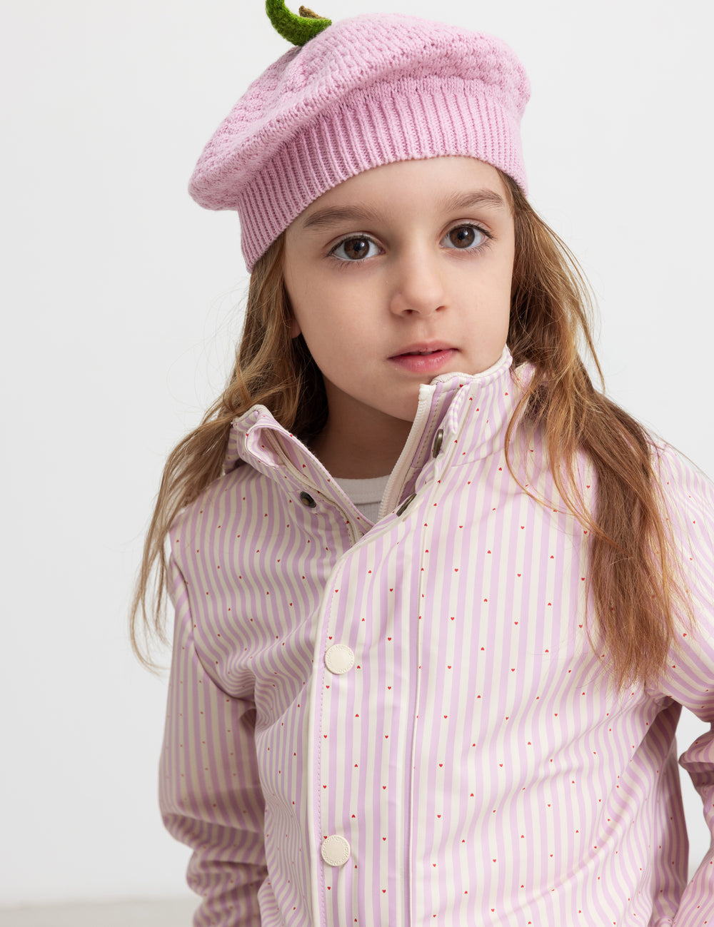 Child wearing a yellow striped raincoat and matching hat.
