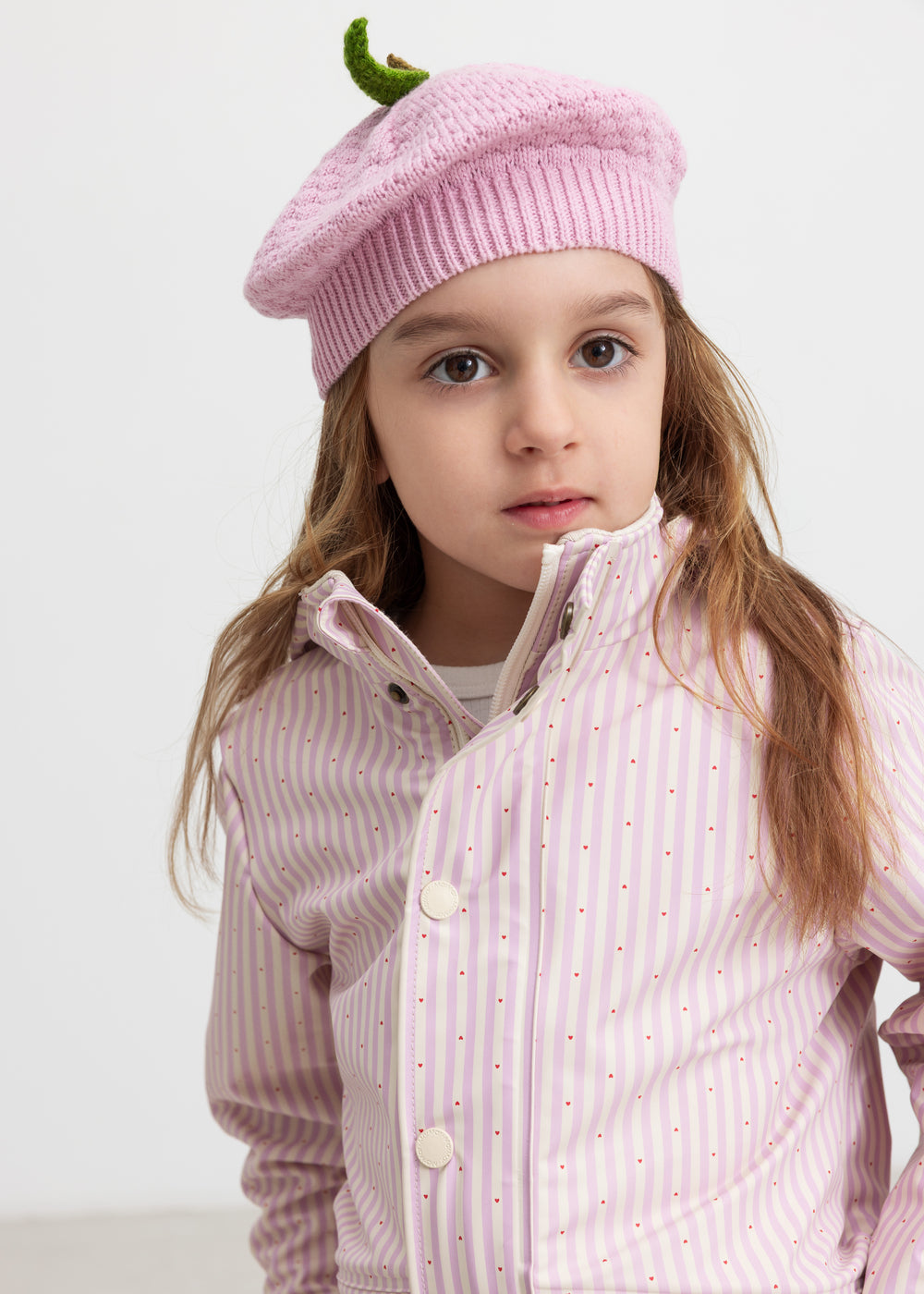 Child wearing a yellow striped raincoat and matching hat.