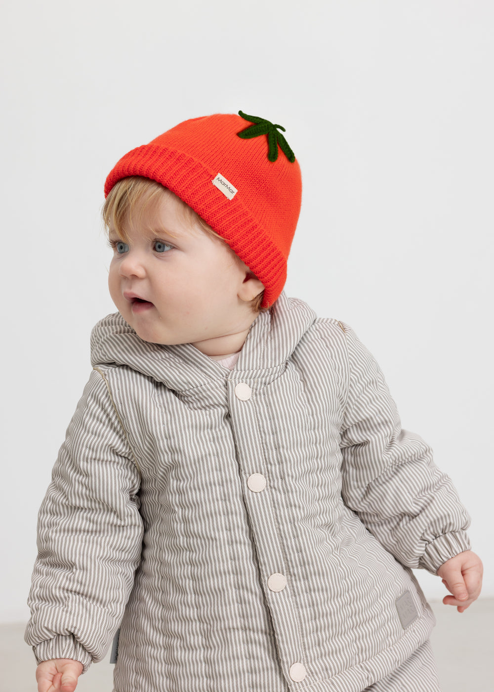 Baby brown thermal jacket with buttons and a red knitted hat