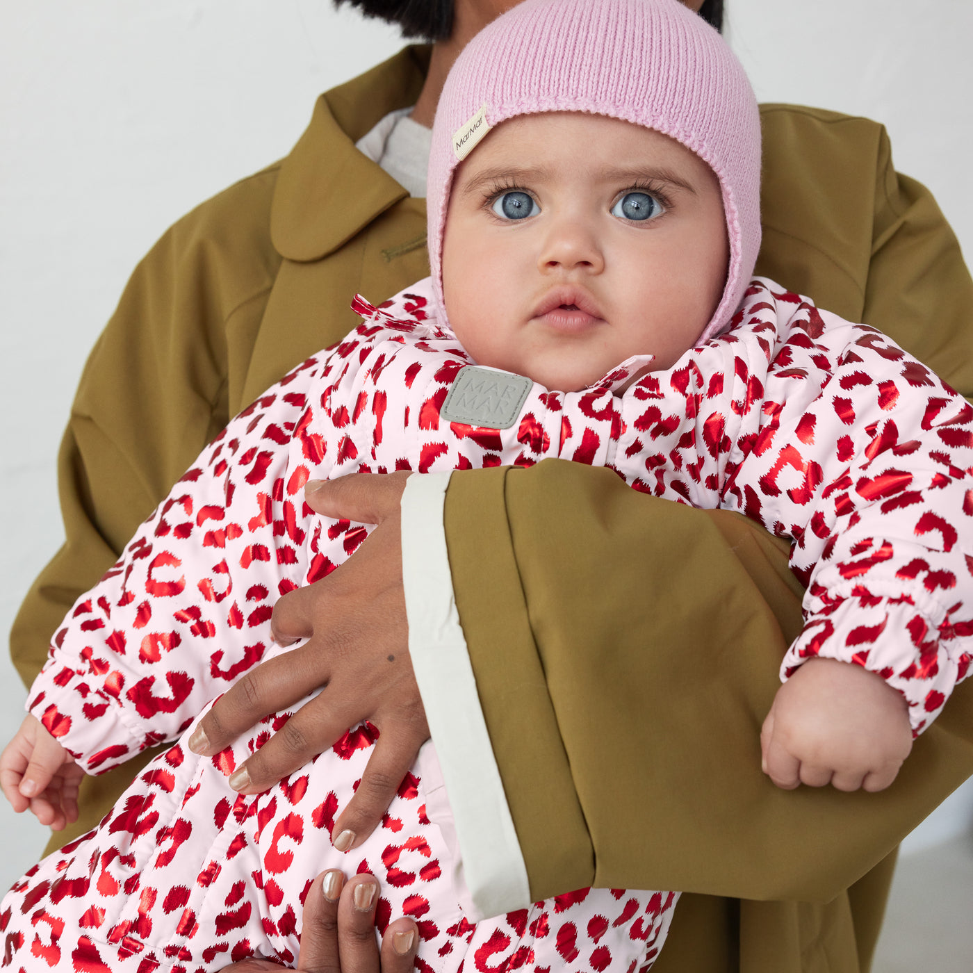 Baby i lyserød strikhue og thermodragt i leopard print