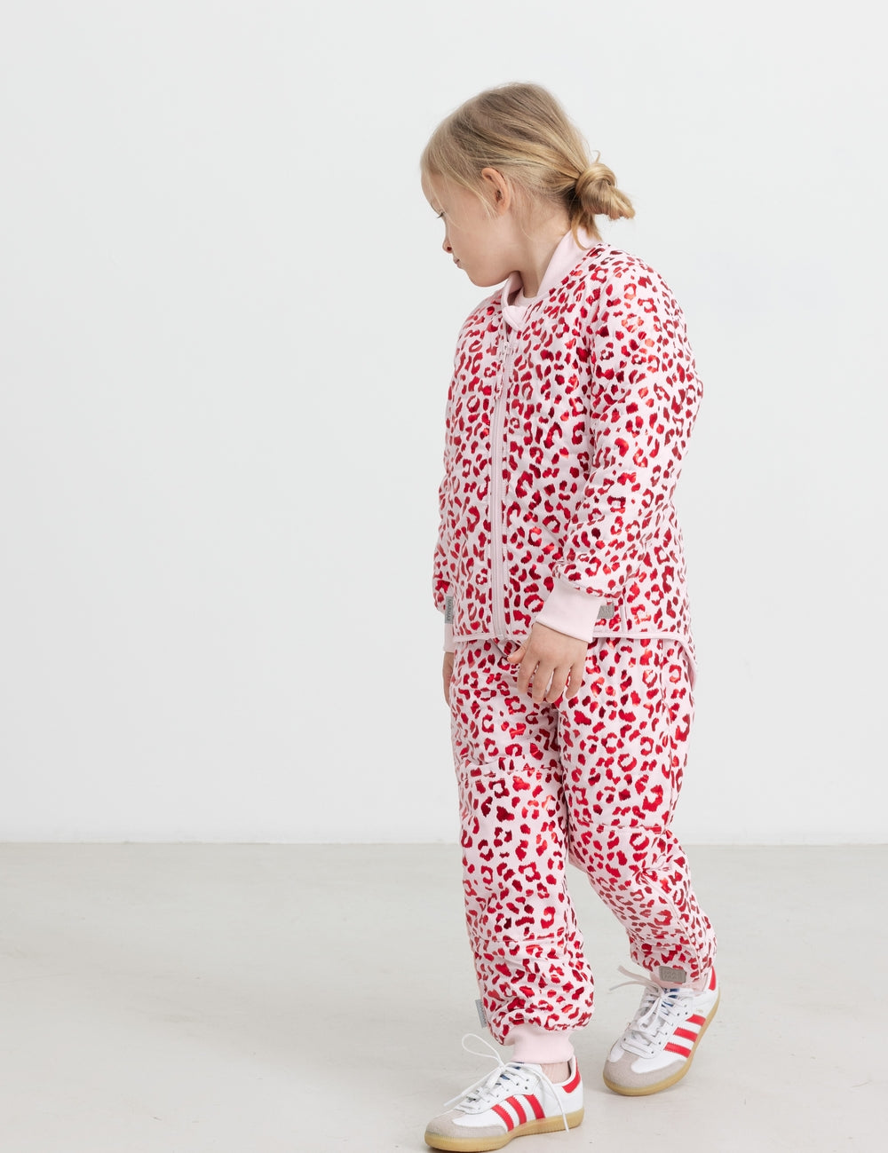 Children wearing bright red thermal pants and a leopard print jacket.