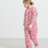 Children wearing bright red thermal pants and a leopard print jacket.