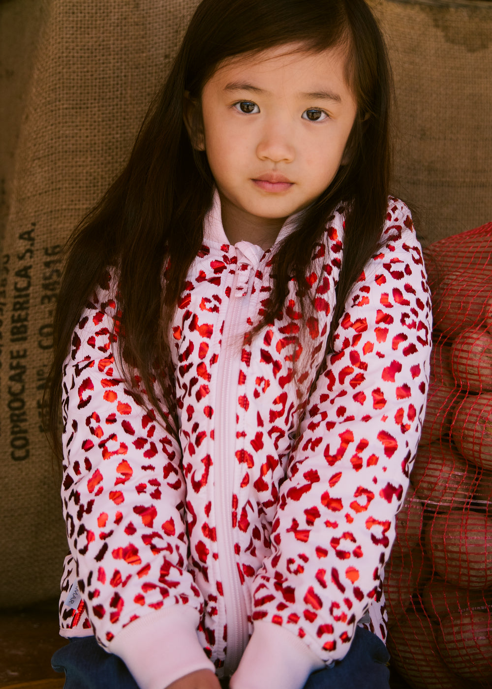 Children in red thermal jackets with leopard print.