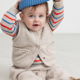 Baby wearing a striped sweater and a blue hat.