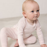 Baby wearing bright red modal baby pants and a t-shirt.