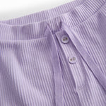 Pink baby bloomers with button closure and a decorative band at the waist.