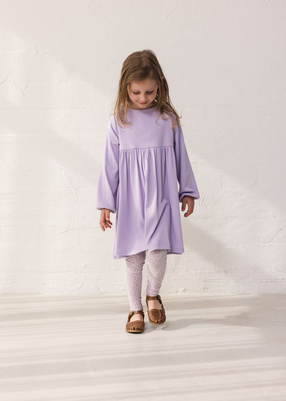 Wearing a purple dress and leopard leggings.