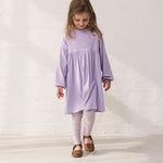 Wearing a purple dress and leopard leggings.