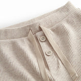 Beige baby bloomers with a drawstring and a decorative band at the waist.