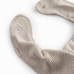 Beige baby salves that close with a button.