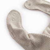 Beige baby salves that close with a button.