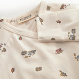 Langärmet bodystocking for a newborn baby with a snap closure and train motif.