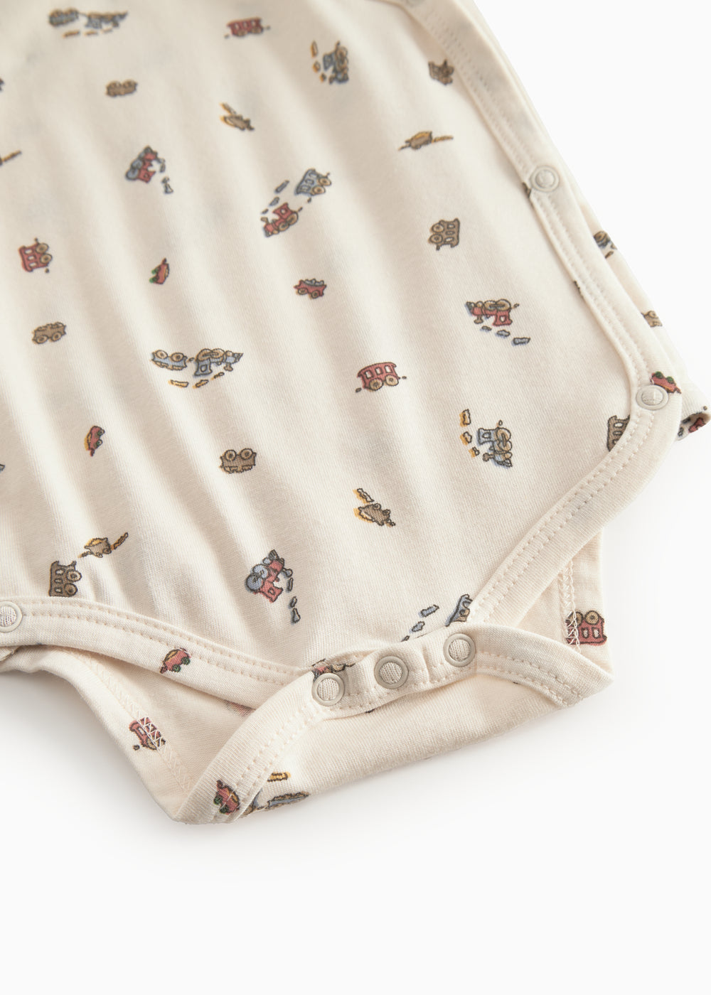 Langärmet bodystocking for a newborn baby with a snap closure and train motif.