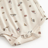 Langärmet bodystocking for a newborn baby with a snap closure and train motif.