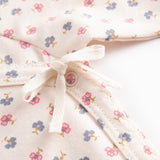 Langærmet bodystocking for a newborn baby with snap closure and flowers.