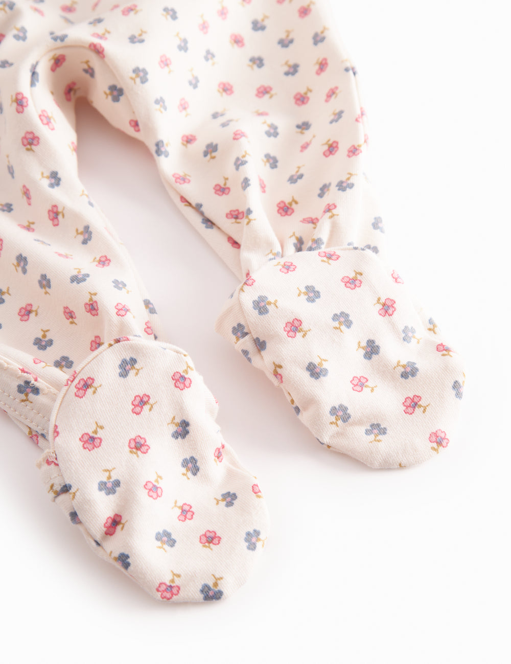 Long-sleeved onesie with feet and flower pattern for a newborn baby