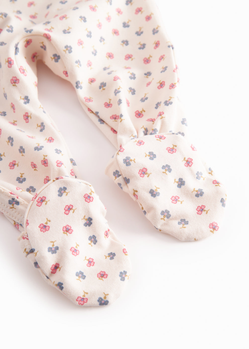 Long-sleeved onesie with feet and flower pattern for a newborn baby