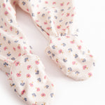 Long-sleeved onesie with feet and flower pattern for a newborn baby