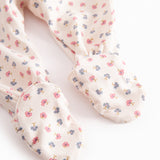 Long-sleeved onesie with feet and flower pattern for a newborn baby
