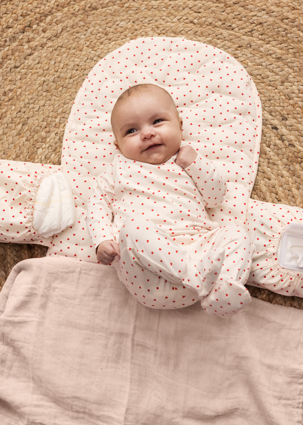 Baby on a puzzle mat with a cute heart print