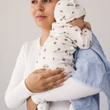 Baby held by a woman with a fabric blanket over her shoulder.