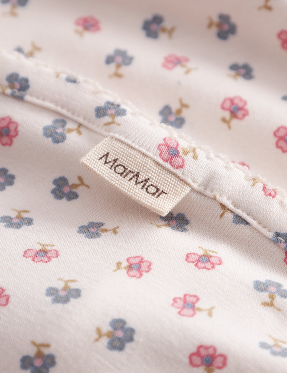 Baby blanket with rounded corners, picot edges, and floral print.