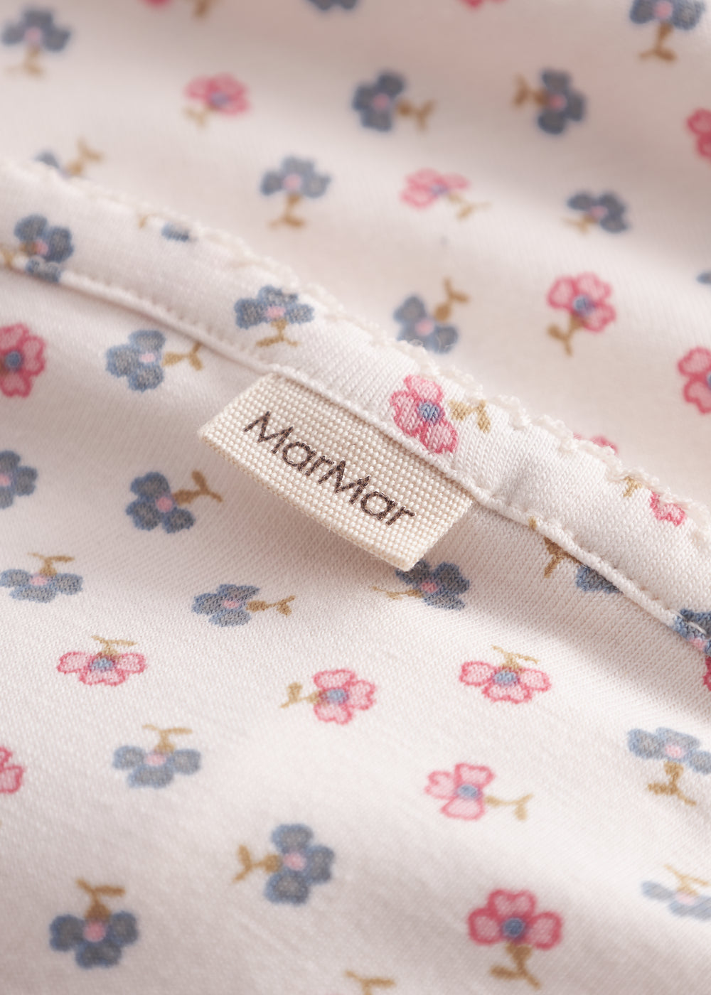 Baby blanket with rounded corners, picot edges, and floral print.