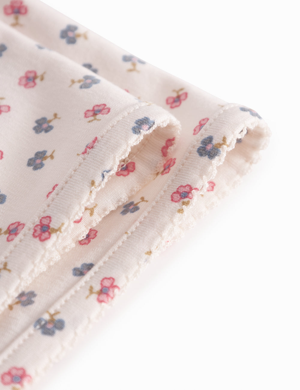 Baby blanket with rounded corners, picot edges, and floral print.