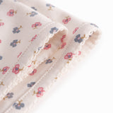 Baby blanket with rounded corners, picot edges, and floral print.
