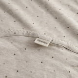 Beige baby blanket with rounded corners, picot edges, and a fine print.