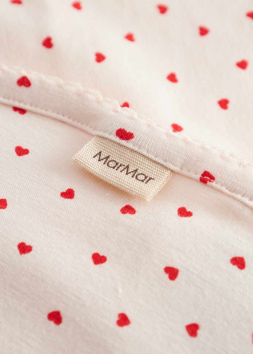 Baby blanket with rounded corners, picot edges, and a fine heart print.